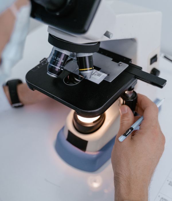 A vet staff examining sample under microscope